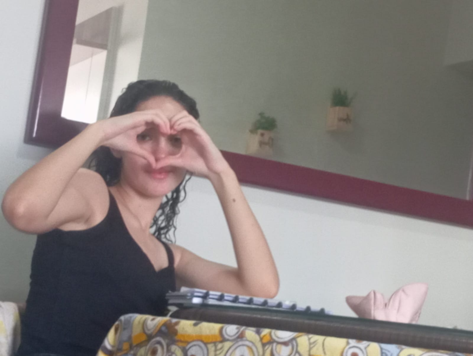 Ela fazendo um coração com as mãos